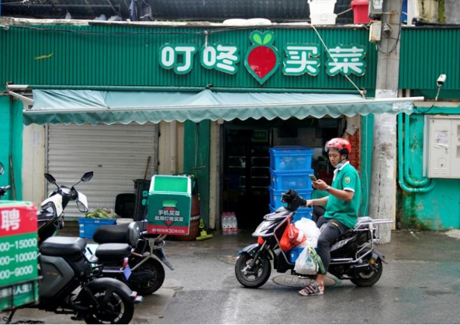중국 신선식품 배달 스타트업체 딩동의 배달원이 2021년 6월 10일 중국 상하이의 한 거리에서 일하고 있다. 사진=로이터