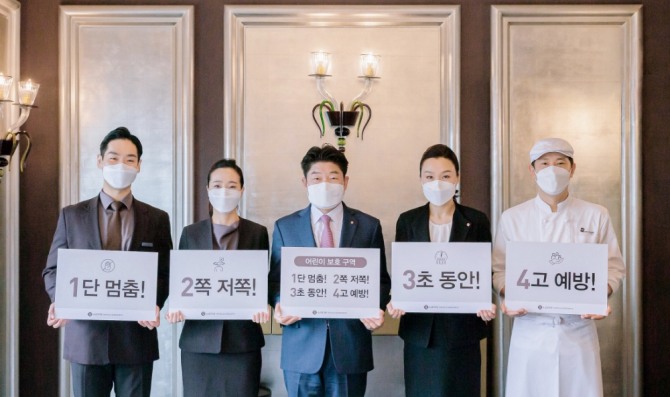 김현식 롯데호텔 대표이사(가운데)가 임직원들과 함께 '어린이 교통안전 릴레이 챌린지'에 참여해 기념사진을 촬영하고 있다. 사진=롯데호텔