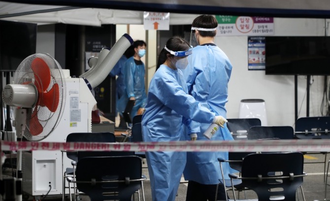 8일 오후 서울 강남구보건소에 설치된 선별진료소에서 의료진들이 소독을 하고 있다. 사진=뉴시스