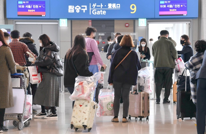 무착륙 관광비행 탑승객들이 면세 쇼핑 물품을 갖고 탑승구로 이동하고 있다. 사진=연합뉴스