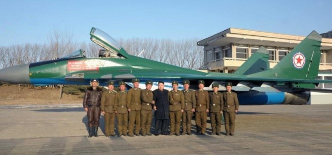 북한 김정은 위원장이 미그-23 전투기 앞에서 조종사들과 함께 기념 사진 촬영을 위해 포즈를 취하고 있다. 사진=조선중앙통신/포브스