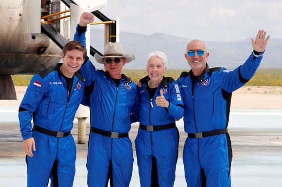 억만장자 미국 사업가 제프 베조스(왼쪽 2번째)가 블루 오리진의 첫 비행을 마친 후 착륙장에서 승무원과 함께 사진을 찍고 있다. 사진=로이터