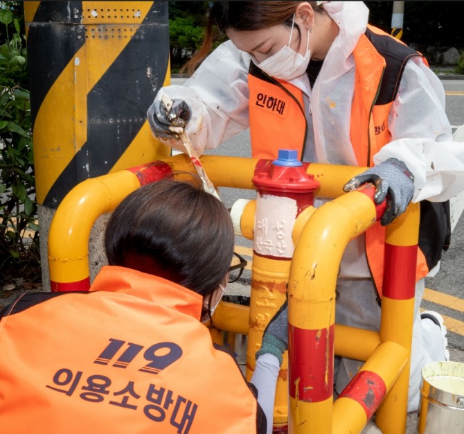 인하대와 청운대 대학생 전문의용소방대원들이 학익초등학교 인근 소화전 도색 작업을 하고 있다.