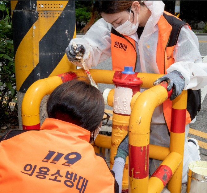 인하대와 청운대 대학생 전문의용소방대원들이 학익초등학교 인근 소화전 도색 작업을 하고 있다.