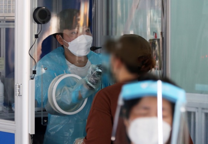 22일 서울 동대문구 보건소에 마련된 선별진료소에서 의료진이 검체를 채취하고 있다. 사진=뉴시스