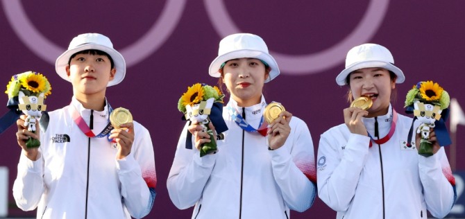 대한민국 양궁 대표팀 안산(오른쪽부터)과 장민희, 강채영이 25일 오후 일본 도쿄 유메노시마 양궁장에서 열린 2020 도쿄올림픽 양궁 여자단체전에서 우승, 시상식에서 금메달을 목에 걸고 포즈를 취하고 있다. 사진=뉴시스