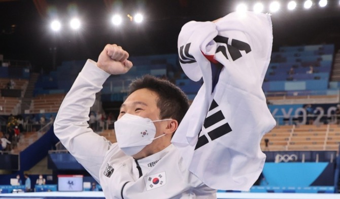 2일 일본 아리아케 체조경기장에서 열린 도쿄올림픽 남자 기계체조 도마 결선에서 금메달을 획득한 신재환이 태극기를 흔들며 환호하고 있다. 사진=연합뉴스