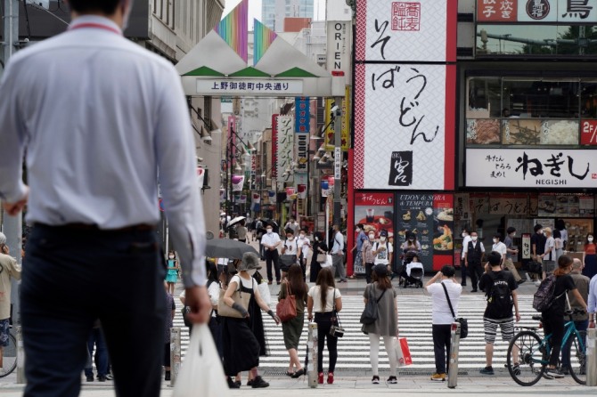 일본 수도 도쿄의 우에노역 부근에 있는 횡단보도에서 지난달 30일 코로나19 예방을 위해 마스크를 착용한 시민들이 신호등이 바뀌기를 기다리고 있다. 사진=뉴시스