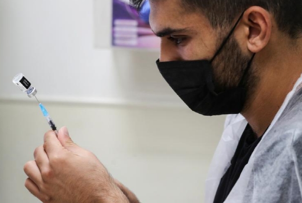 이스라엘의 한 의료진이 코로나19 백신접종을 하기 위해 준비하고 있는 모습. 사진=로이터