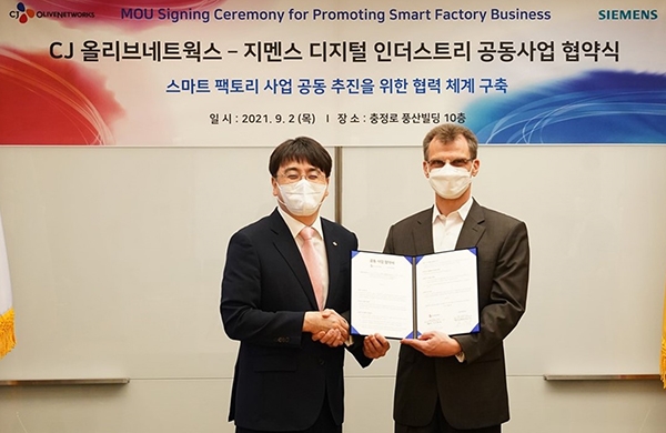 한국지멘스 본사에서 열린 업무협약식에서 차인혁 CJ올리브네트웍스 대표(왼쪽)와 토마스 슈미드(ThomasSchmid) 한국지멘스 디지털 인더스트리 부문 대표가 기념사진을 촬영하고 있다.