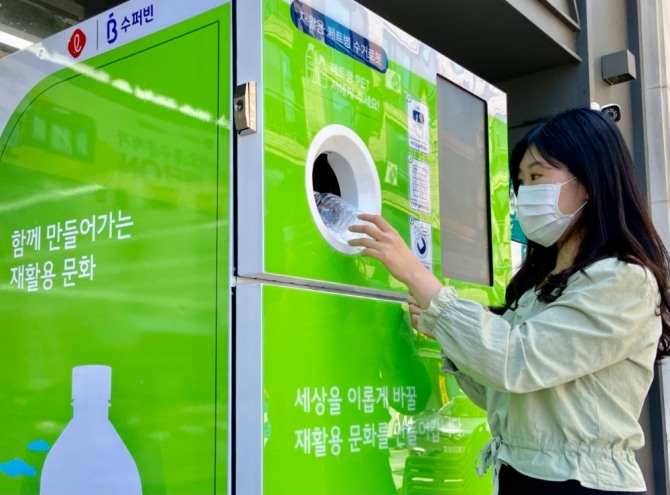 한 고객이 페트 회수 로봇을 이용하고 있다. 사진=롯데지주