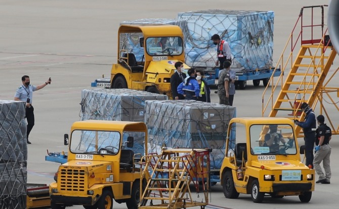 6일 오후 인천공항 화물터미널에 도착한 코로나19 모더나 백신 255만 2000회분을 수송 관계자들이 옮기고 있다. 사진=뉴시스