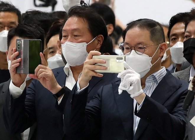 최태원 SK그룹 회장(왼쪽)과 조현상 효성그룹 부회장(오른쪽)이 8일 오전 경기 고양시 킨텍스에서 열린 '2021 수소모빌리티+쇼' 현대자동차 부스에서 트레일러 드론을 스마트폰으로 촬영하고 있다. 사진=뉴시스