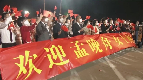 중국 광둥성 선전의 바오안 국제공항에서 캐나다에서 도착한 멍완저우 화웨이 최고재무책임자(CFO) 겸 부회장를 환영하는 현수막 뒤에서 사람들이 중국 국기를 흔들고 있다. 사진=로이터