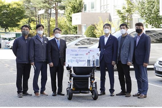 한국교통안전공단 이장규 강원본부장(오른쪽 3번째)이 ㈜만도 관계자 등과 오뚝이 휠체어 선정 가정을 방문해 휠체어를 전달하고 기념사진을 찍고 있다. 사진=한국교통안전공단 