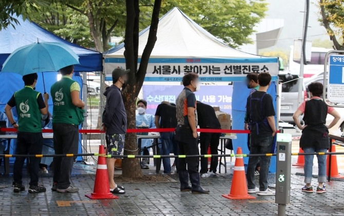 지난 6일 오전 서울 마포구 마포농수산물시장에 설치된 찾아가는 선별진료소에서 상인들이 검사를 받고 있다. 사진=뉴시스