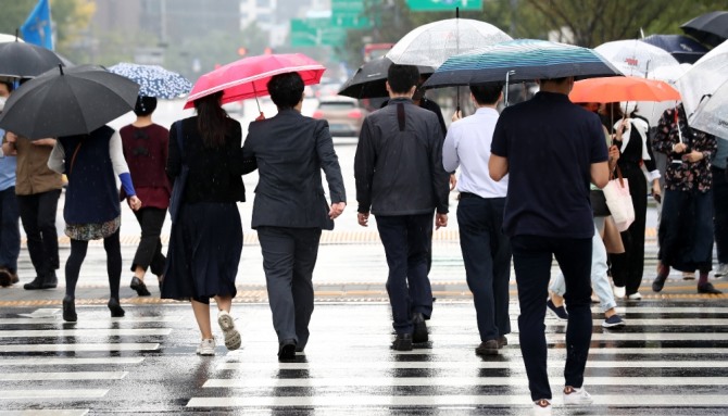 지난달 서울 중구 명동 사거리 인근에서 우산을 쓴 시민들이 발걸음을 재촉하고 있다. 사진=뉴시스