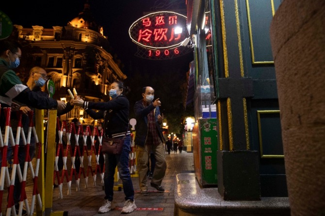 코로나19 델타 변이 확산으로 엄격한 방역조치가 내려진 중국 헤이룽장성 하얼빈에서 10월 2일 시민들이 예방을 위해 마스크를 착용한 채 번화가에 있는 가게들을 찾고 있다. 사진=뉴시스