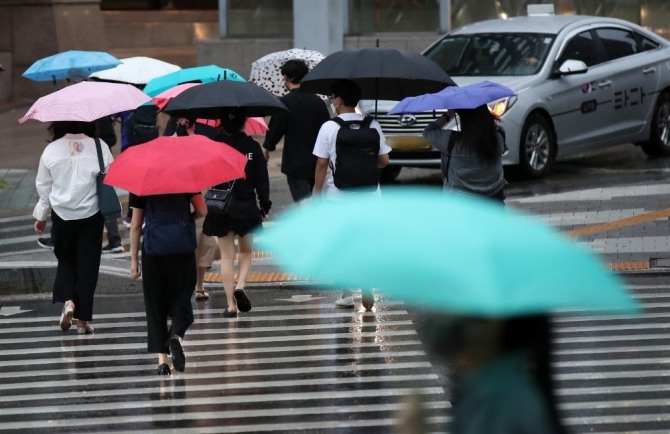 서울 중구의 한 도로에서 시민들이 우산을 쓰고 지나가고 있다. 사진=뉴시스