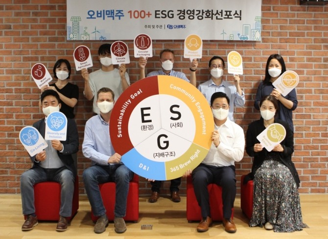 '2021 ESG 워크숍'에 참석한 배하준 대표(앞줄 왼쪽 두 번째)와 구자범 수석 부사장(앞줄 왼쪽 세 번째)이 임직원들과 100+지속가능경영 목표를 들어 보이고 있다. 사진=오비맥주