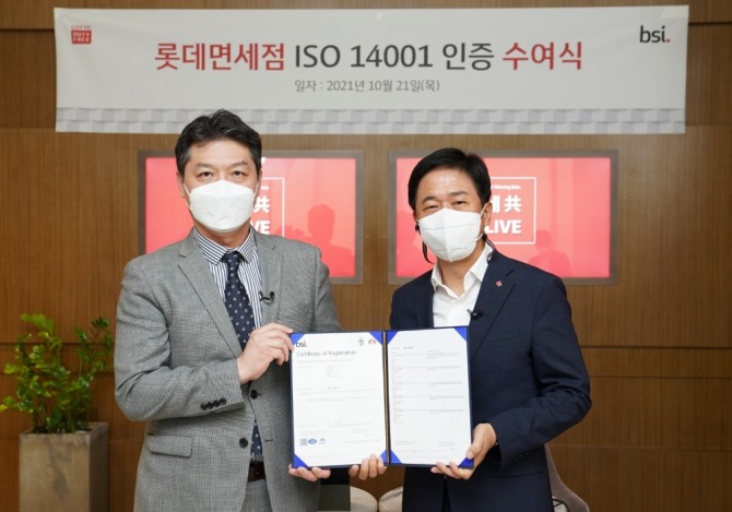 롯데면세점이 ‘환경경영시스템 ISO 14001’ 인증을 획득했다.  21일 오후 롯데면세점 월드타워점에서 연 인증 수여식에 임성환 영국표준협회 한국지사 본부장(왼쪽), 이갑 롯데면세점 대표이사가 참석했다. 사진=롯데면세점  