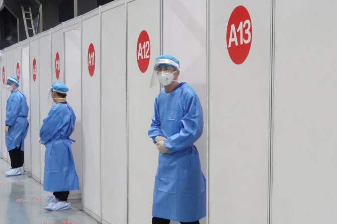 중국 베이징의 코로나19 접종센터에서 방역직원들이 접종부스 밖에서 대기하고 있는 모습. 사진=로이터