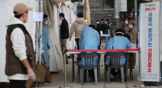 동대문종합시장 관련 확진자가 80명으로 집계된 19일 오전 서울 종로구 흥인지문 인근에 설치된 찾아가는 선별진료소에서 시장 종사자들이 검사를 받기 위해 대기하고 있다. 사진=뉴시스
