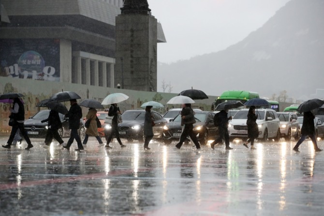 8일 오전 강풍을 동반한 비가 내리는 서울 종로구 광화문 네거리에서 시민들이 우산을 쓰고 걸어가고 있다. 사진=뉴시스