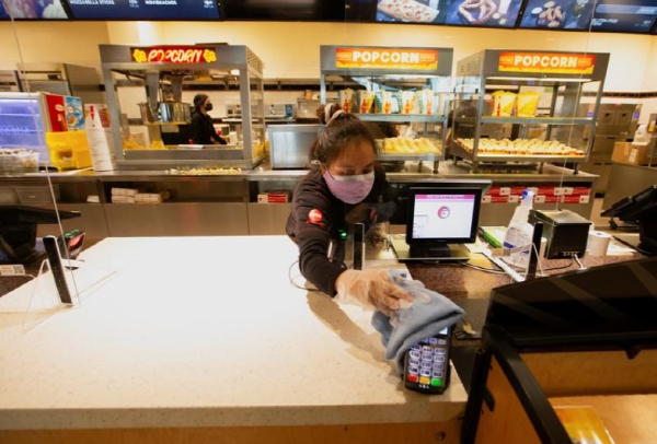 미국의 한 패스트푸드 직원이 신용카드 단말기를 소독하고 있는 모습. 사진=로이터