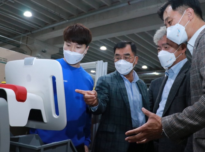 강신호 CJ대한통운 대표이사(왼쪽에서 두 번째)가 경기도 동탄 소재 TES 이노베이션 센터에서 '자율주행 이송로봇(AMR)' 기반 '오더피킹 시스템'을 보고 있다. 사진=CJ대한통운
