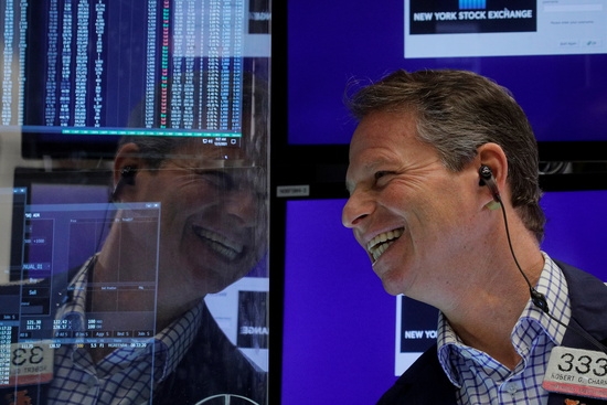 뉴욕증권거래소(NYSE)의 한 트레이더가 환화게[ 웃고 있다. 사진=로이터