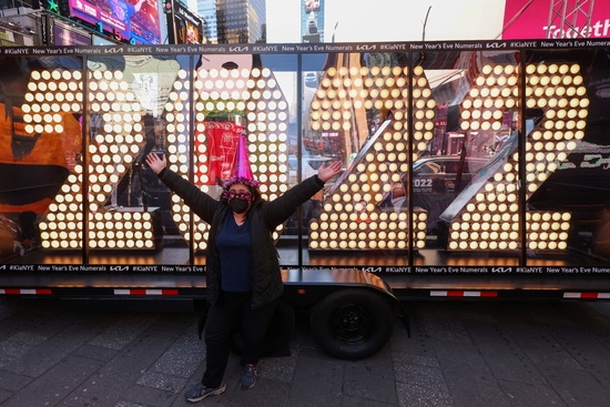 한 시민이 뉴욕 맨해튼에서 새해 전야 행사를 앞두고 타임스퀘어에 배달된 2022 숫자 앞에서 포즈를 취하고 있다. 사진=로이터