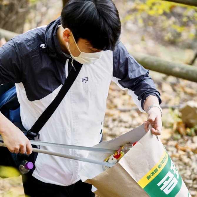 지난해 11월 '곰표 플로깅하우스' 캠페인 참여자가 소래산을 등반하며 쓰레기를 줍고 있다. 사진=곰표하우스 홈페이지