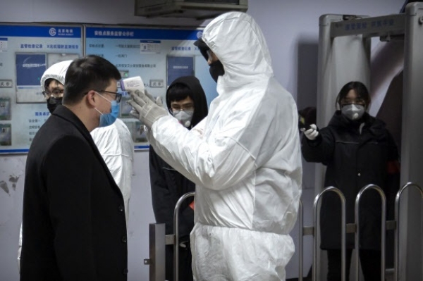 중국 베이징 전철역에서 위생방호복을 입은 직원이 승객의 체온을 재는 모습. 사진=연합뉴스