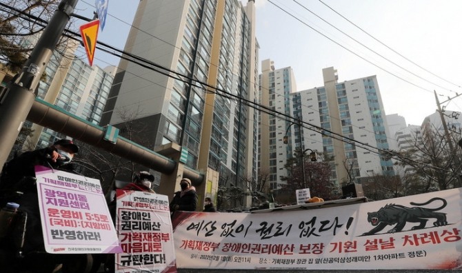 전국장애인차별철폐연대 회원들이 1일 오전 서울 마포구에 위치한 홍남기 기획재정부 장관 자택 앞에서 '기획재정부 장애인권리예산 보장 기원 설날 차례상' 집회를 열고 있다. [사진=뉴시스]