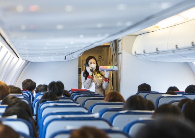 지난 1월 티웨이항공과 저장성 관광마케팅센터가 진행한 무착륙관광비행에서 티웨이항공 승무원과 탑승자들이 이벤트를 함께하고 있다. 사진=티웨이항공