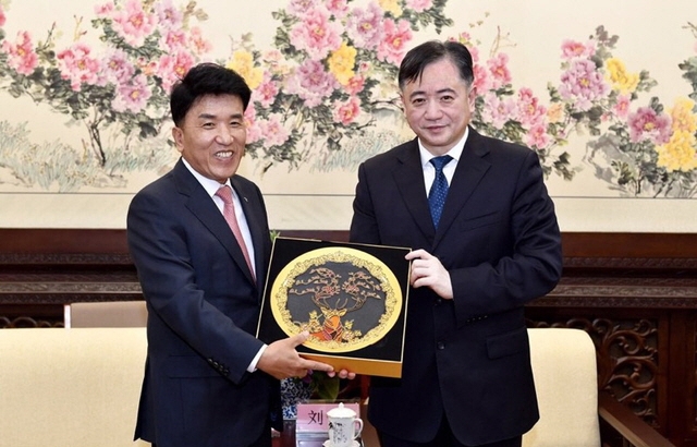 함영주 하나금융그룹 부회장(왼쪽)이 지난 2019년 10월 중국 길림성 장춘시정부 회의실에서 리우신 장춘시 시장으로부터 명예시민 선정 기념패를 수여받고 기념촬영을 하고 있다. [사진=하나금융그룹]