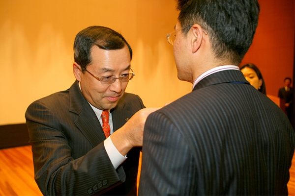구자홍 회장이 2007년 신입사원에게 LS배지를 달아주고 있다. 사진=LS그룹