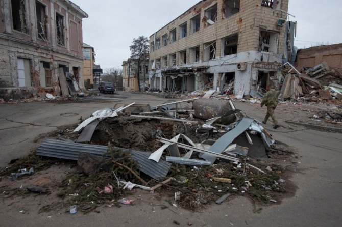 러시아의 우크라이나 공격이 계속되고 있는 가운데 3월 14일 우크라이나 군인 한 명이 수미 지역 오르티카 마을의 폭탄 분화구를 지나가고 있다. 사진=로이터