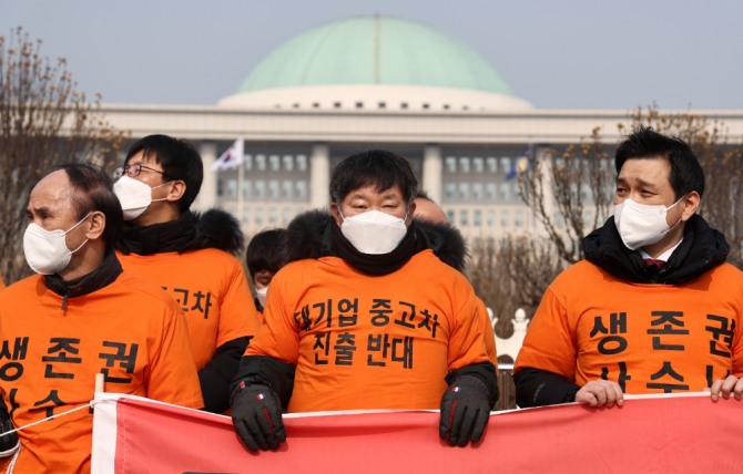 한국자동차매매사업조합연합회원들이 현대기아차 중고차시장 진출을 반대하는 내용의 현수막을 들고 있다. 사진=연합뉴스