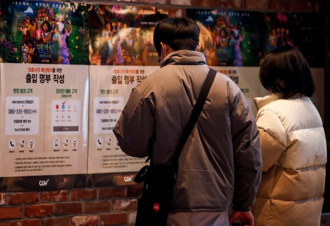 서울 시내 한 영화관에서 관람객이 출입명부 작성 관련 안내문을 읽고 있다. 사진=뉴시스