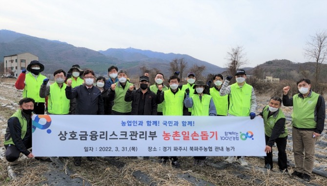 임도곤 농협 상호금융리스크관리부장(앞줄 오른쪽 세번째)과 권욱민 파주시지부장(다섯번째)을 비롯한 직원들이 31일 경기도 파주시 농가의 영농철 일손돕기에 참여했다. [사진=농협]