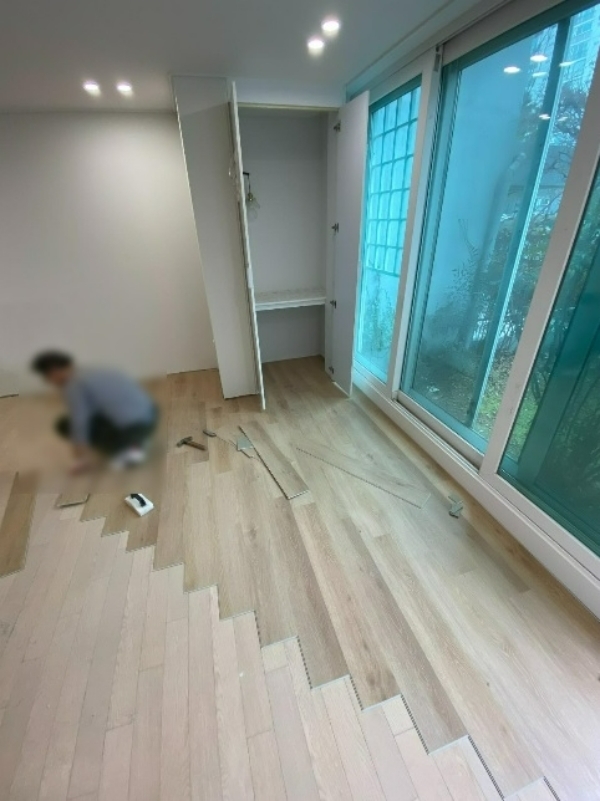 한 인테리어 시공 관계자가 바닥 철거와 평탄화 작업을 하지 않고 이노플러스 바닥재를 시공하고 있다. 사진=김태형 기자
