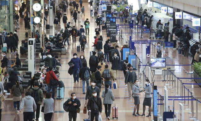 일본 도쿄의 하네다 공항 국내선 터미널에서 코로나19 확산 방지를 위해 마스크를 쓴 사람들이 걸어가고 있다.  [사진=뉴시스]