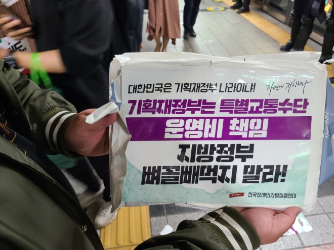 전국장애인차별철폐연대 회원들이 21일 서울 종로구 지하철 2호선 시청역에서 '출근길 지하철 타기' 시위를 하고 있다. [사진=글로벌이코노믹DB]