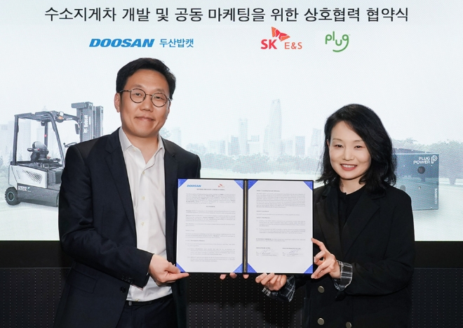 김상영 두산밥캣 글로벌 전략 담당 전무(왼쪽)와 이지영 SK E&S 부사장이 26일 경기도 성남시 분당두산타워에서 열린 양해각서 체결식에서 기념 촬영을 하고 있다. 사진=두산밥캣