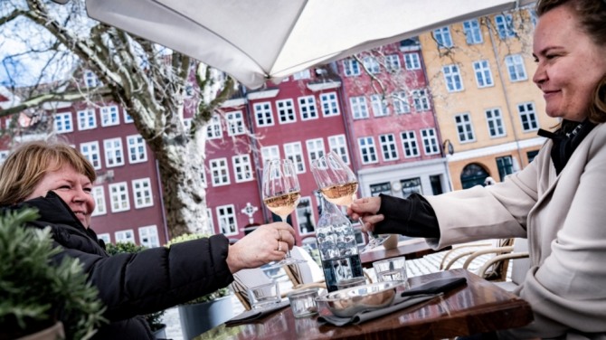 코로나 방역 단계가 완화된 덴마크 수도 코펜하겐 중심가의 카페에서 손님들이 포도주를 즐기고 있는 모습. 사진=로이터