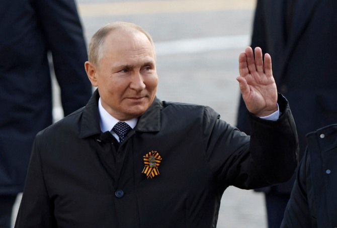 지난 9일(현지시간) 러시아 수도 모스크바에서 열린 2차대전 승전 기념일 행사에 참석한 블라디미르 푸틴 대통령(오른쪽)이 참석자들에게 손을 흔들어 보이고 있다. 사진=로이터