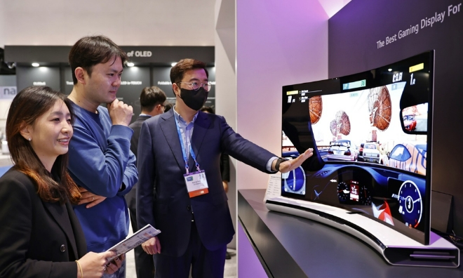 'SID 2022' 전시회 관람객들이 LG디스플레이 직원에게 회사가 개발한 '42형 벤더블 게이밍 OLED'에 대한 설명을 듣고 있다. 사진=LG디스플레이