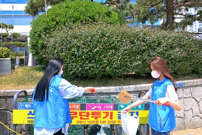18일 부산 광안리 해수욕장에서 에어부산 직원들이 환경정화 봉사활동을 실시하고 있다. 사진=에어부산